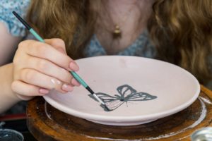 a child painting a bowl